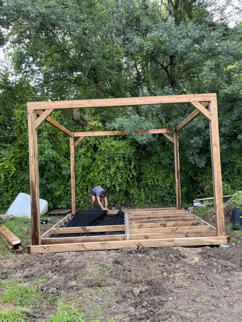 Charpentier paysagiste assemblant le solivage d’un gazebo en bois