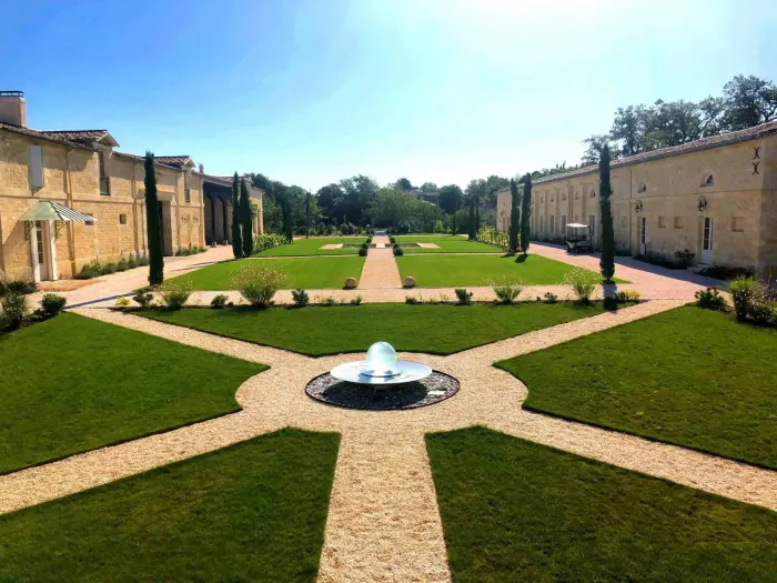 Vue d'ensemble du parc requalifié du château Gassies, allées pavées et fontaine